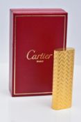 A CARTIER GOLD PLATED LIGHTER, oval rectangular form with engine turned engraving decoration, signed