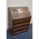 AN OAK LINENFOLD BUREAU with two drawers, width 76cm x 44cm x height 100cm (no key)