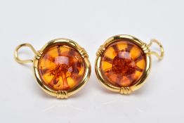 A PAIR OF YELLOW METAL, AMBER CABOCHON EARRINGS, each designed with a circular cabochon amber within