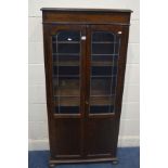 AN EARLY TO MID 20TH CENTURY OAK LEAD GLAZED TWO DOOR BOOKCASE, on flat bun feet, width 75cm x depth