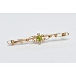 A YELLOW METAL, PERIDOT AND SPLIT PEARL BROOCH, designed with a central circular cut collet set