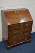 A REPRODUCTION WALNUT BUREAU, with a fitted interior, above four exterior drawers, on bracket