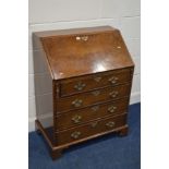 A REPRODUCTION WALNUT BUREAU, with a fitted interior, above four exterior drawers, on bracket