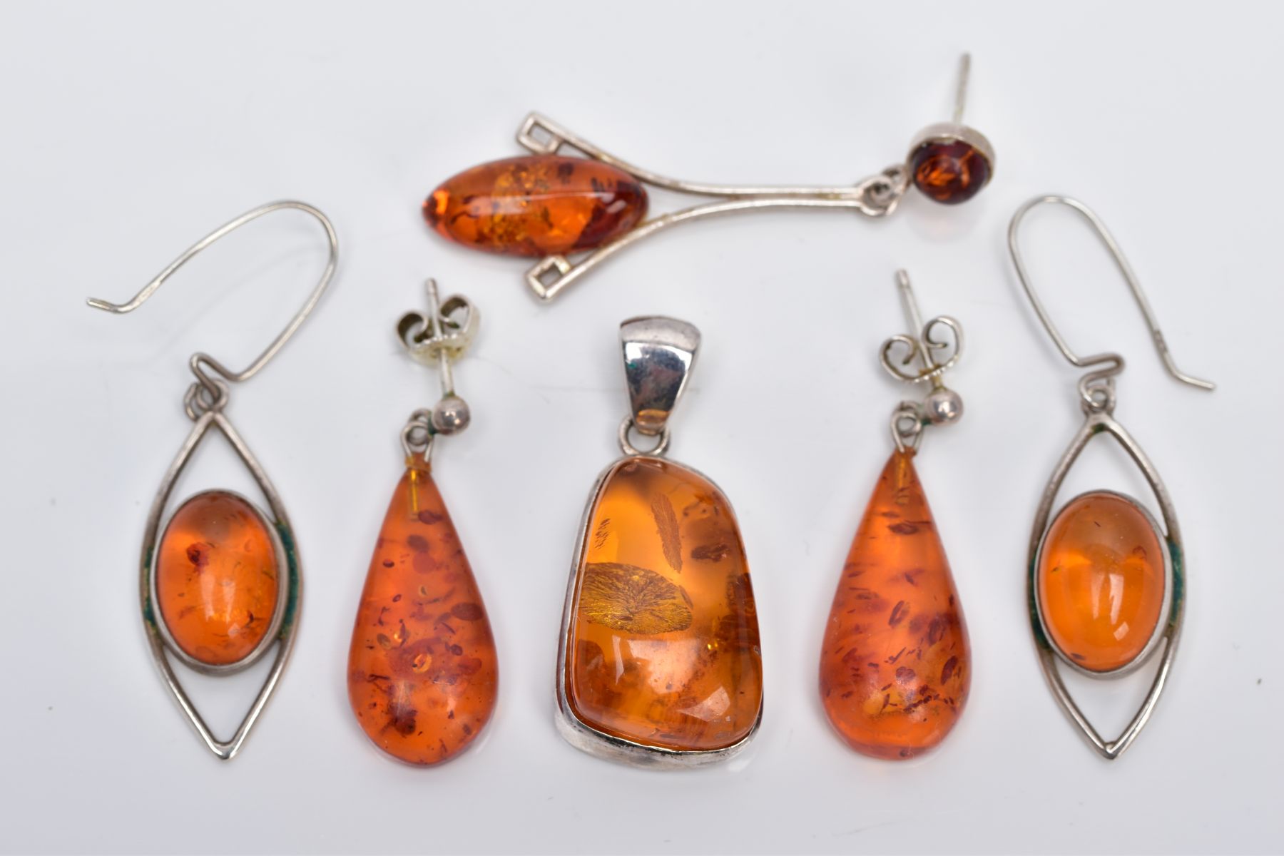 A COLLECTION OF MODERN AMBER JEWELLERY, to include an abstract shaped pendant, two pairs of drop