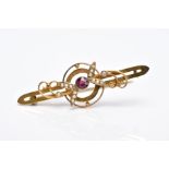 AN EARLY 20TH CENTURY GARNET AND SPLIT PEARL BAR BROOCH with scroll and foliate detail, stamped '