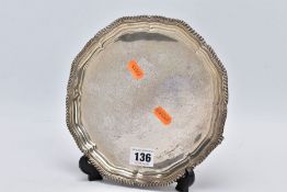 A SILVER SALVER, of a plain polished design and a textured wavy rim, raised on three scroll feet,