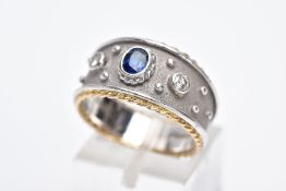 AN 18CT GOLD SAPPHIRE AND DIAMOND RING, the bi-coloured wide band, set with a central oval cut