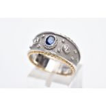 AN 18CT GOLD SAPPHIRE AND DIAMOND RING, the bi-coloured wide band, set with a central oval cut