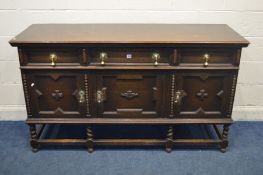 AN EARLY 20TH CENTURY OAK GEOMETRIC SIDEBOARD, with three drawers, cupboard doors, large brass