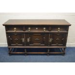 AN EARLY 20TH CENTURY OAK GEOMETRIC SIDEBOARD, with three drawers, cupboard doors, large brass