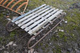 A VINTAGE WOODEN SLATTED SLEIGH on a tubular frame, length 86cm x depth 42cm