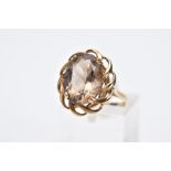 A 9CT GOLD SMOKY QUARTZ RING, designed with a claw set, oval cut smoky quartz within an openwork