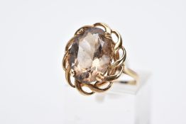 A 9CT GOLD SMOKY QUARTZ RING, designed with a claw set, oval cut smoky quartz within an openwork