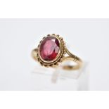 A 9CT GOLD GEMSET RING, designed with an oval red stone assessed as tourmaline, within a collet