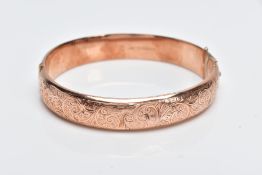 A 9CT ROSE GOLD BANGLE, hollow hinged bangle with a decorative foliate engraved design to the one