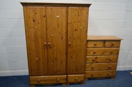 A PINE THREE DOOR WARDROBE, width 135cm x depth 60cm x height 183cm and a chest of two over four