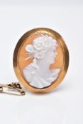 A YELLOW METAL CAMEO BROOCH, of an oval design depicting a lady in profile within a collet mount and