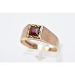 A 9CT GOLD GENTS SIGNET RING, designed with a square cut red stone assessed as paste, within a