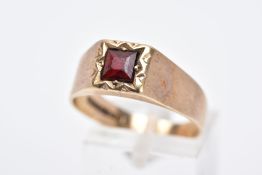 A 9CT GOLD GENTS SIGNET RING, designed with a square cut red stone assessed as paste, within a