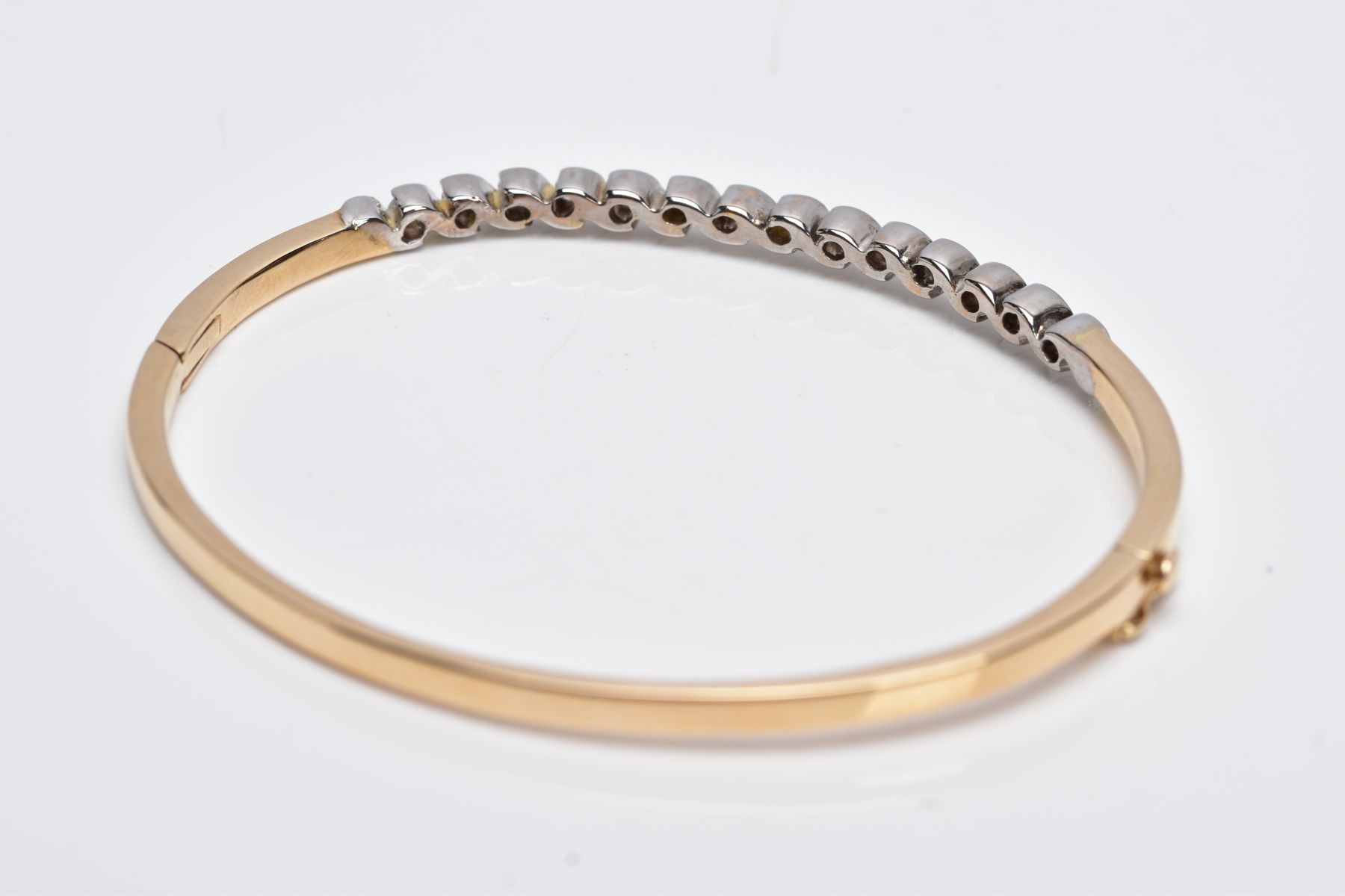 A YELLOW METAL DIAMOND BANGLE, the hinged bangle designed with a row of crossover mounted round - Image 4 of 6