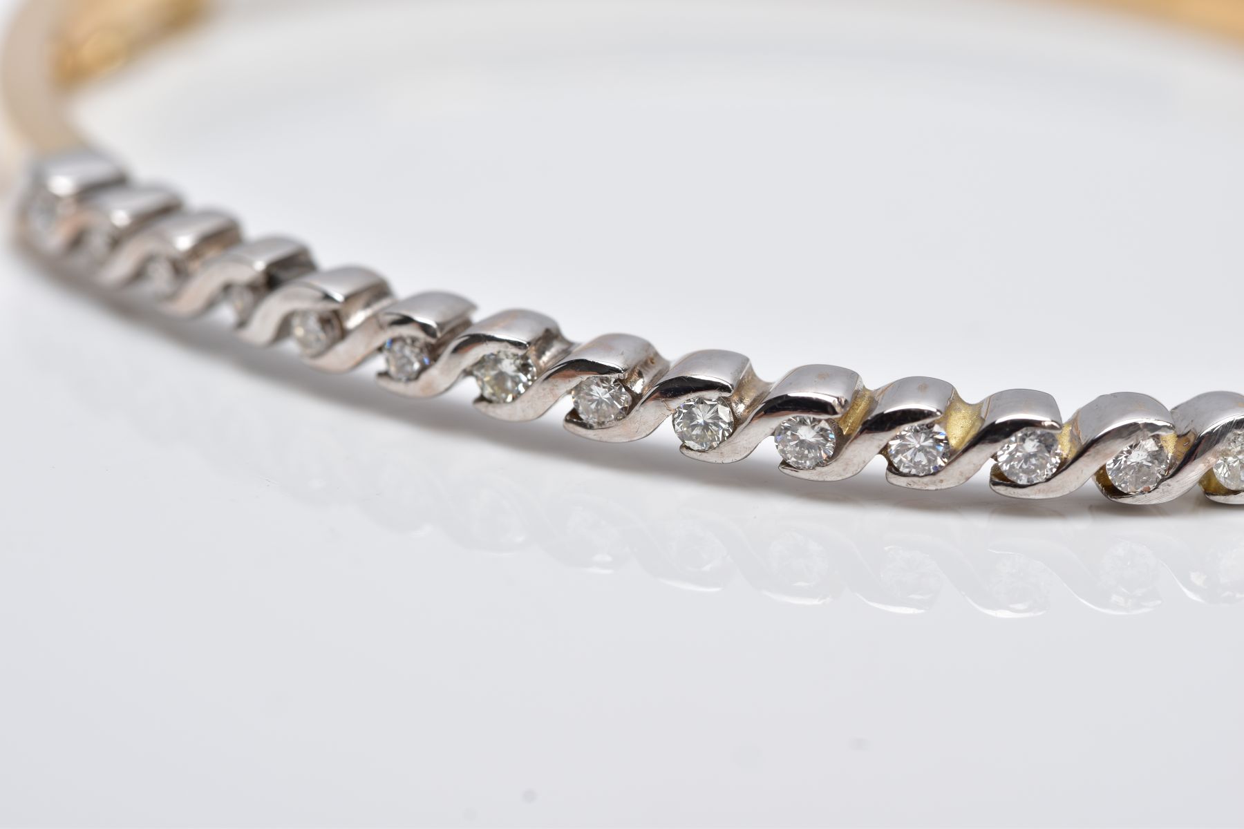 A YELLOW METAL DIAMOND BANGLE, the hinged bangle designed with a row of crossover mounted round - Image 2 of 6