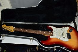 A 2000 USA FENDER STRATOCASTER in cherry sunburst with a maple neck, rosewood fingerboard,