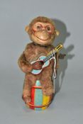 A CLOCKWORK MONKEY PLAYING A GUITAR, nylon plush monkey with plastic face, rubber hands and feet,