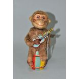 A CLOCKWORK MONKEY PLAYING A GUITAR, nylon plush monkey with plastic face, rubber hands and feet,