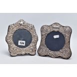 TWO ORNATE SILVER FRAMES, each with a decorative cherub and foliate embossed design, vacant