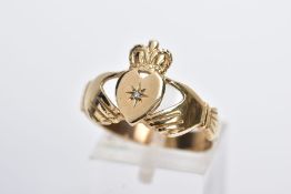 A 9CT GOLD CLADDAGH DIAMOND RING, designed with a star set single cut diamond, on a wide band