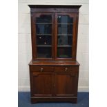 AN EDWARDIAN MAHOGANY TWO DOOR BOOKCASE, with two drawers above double cupboard doors, width 107cm x