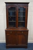 AN EDWARDIAN MAHOGANY TWO DOOR BOOKCASE, with two drawers above double cupboard doors, width 107cm x