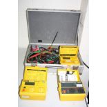 AN ALUMINIUM CASE CONTAINING THREE ROBINS ELECTRICAL TEST METERS including a KMP-3050DL insulation-