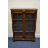 A TITCHMARSH AND GOODWIN OAK GLAZED TWO DOOR BOOKCASE, with three glass adjustable shelves, width