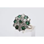 AN EMERALD AND DIAMOND CLUSTER RING, the yellow metal ring designed with a large slightly raised