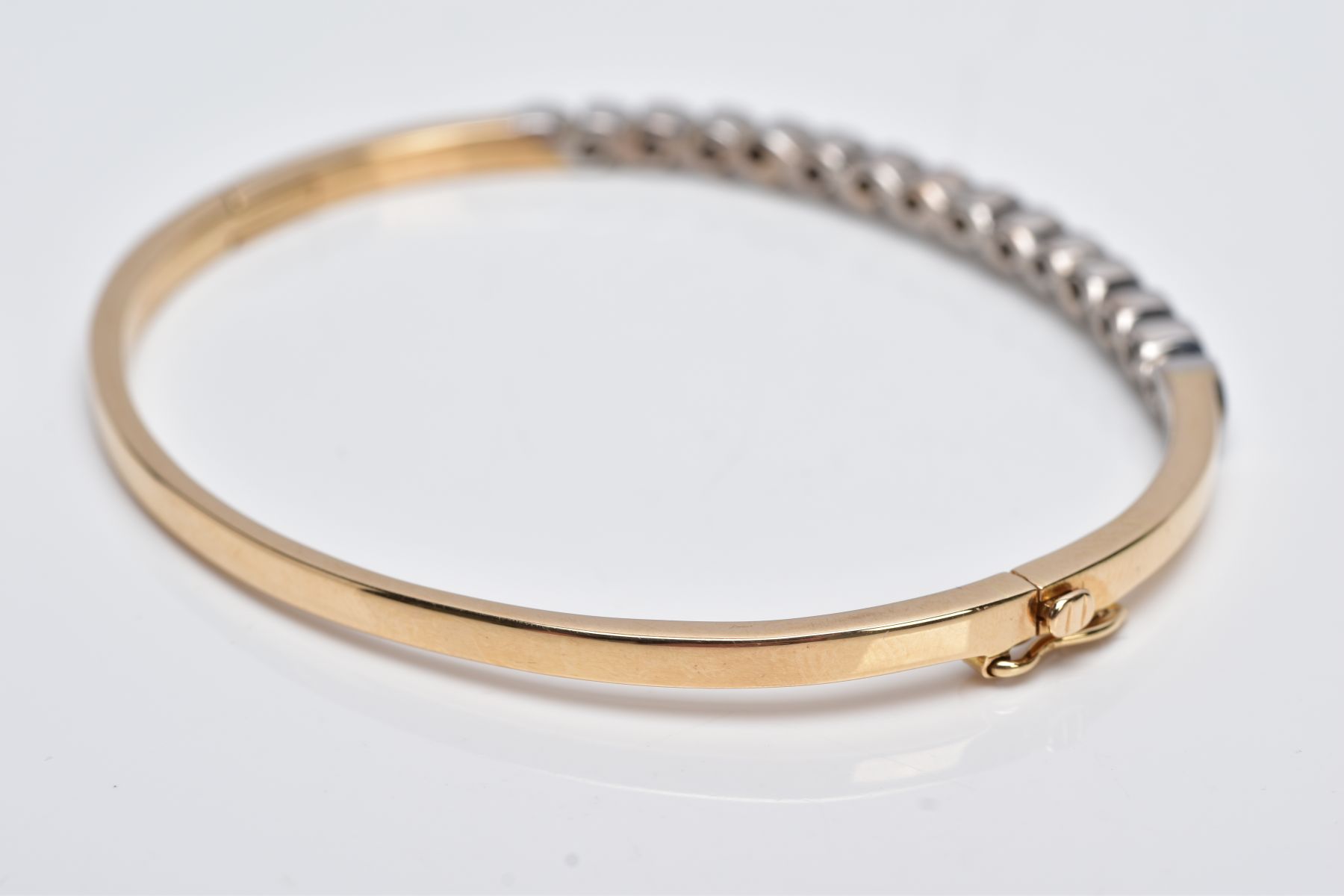 A YELLOW METAL DIAMOND BANGLE, the hinged bangle designed with a row of crossover mounted round - Image 5 of 6