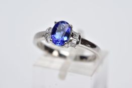 A TANZANITE AND DIAMOND PLATINUM RING, designed with a central claw set, oval cut tanzanite,