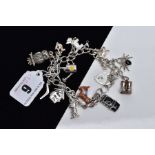 A WHITE METAL CHARM BRACELET, suspending twelve charms in forms such as a decorative enamel donkey