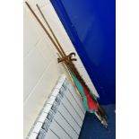 A BUNDLE OF WALKING STICKS, FISHING UMBRELLA, damaged pool cue, two sections from a three section
