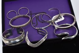 A COLLECTION OF SILVER AND WHITE METAL BANGLES AND A PAIR OF HOOP EARRINGS, to include a silver