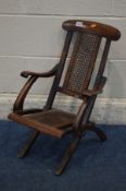 AN EARLY 20TH CENTURY MAHOGANY AND BERGERE FOLDING CHILDS CAMPAIGN CHAIR