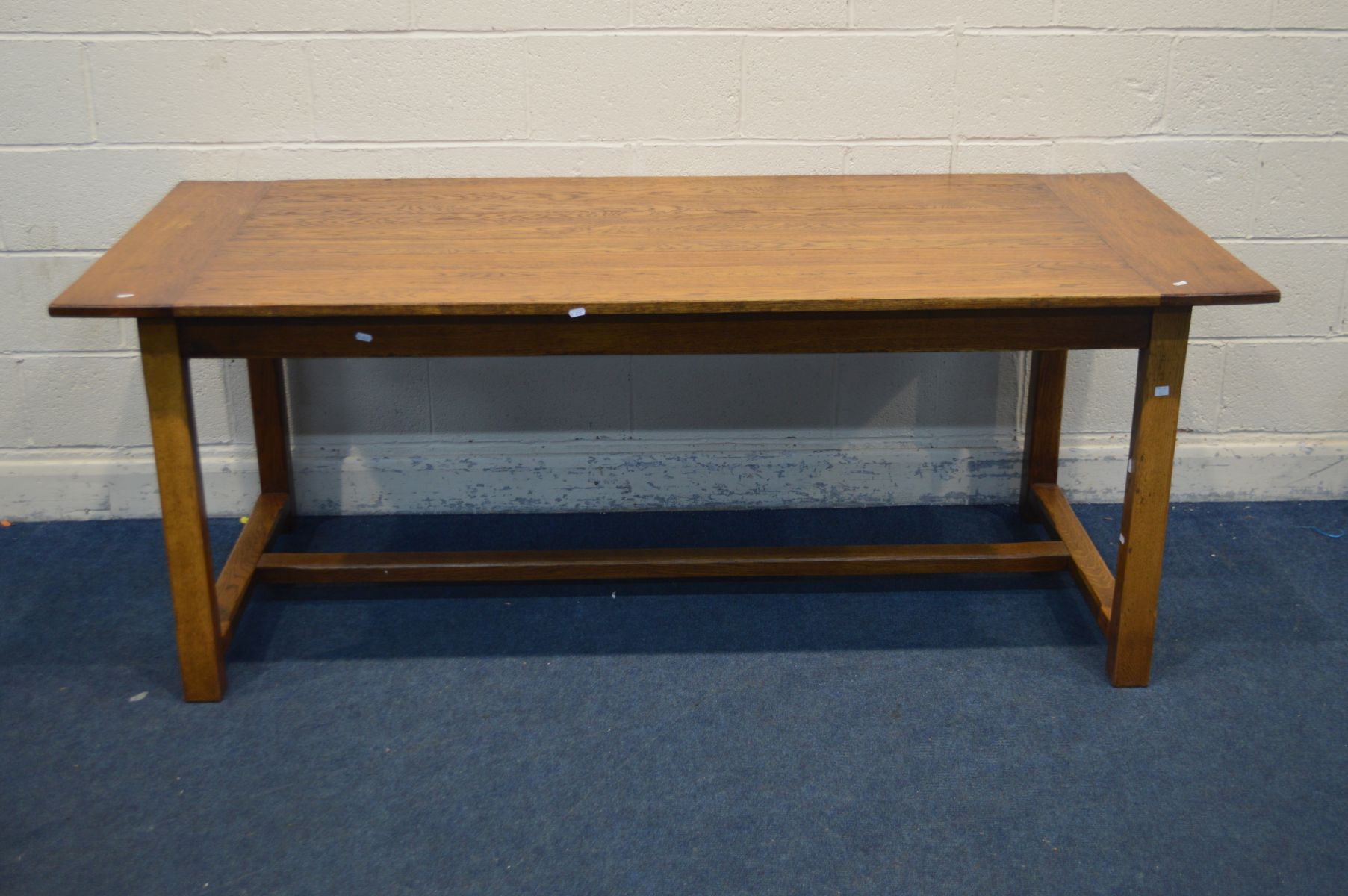 A REPRODUCTION OAK REFECTORY TABLE, in an 18th century style, plank top, on chamfered legs united by