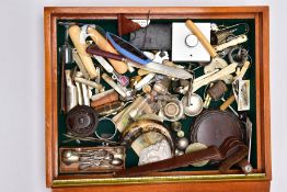 A WOODEN DISPLAY BOX WITH CONTENTS, to include items such as white metal salt spoons, sugar tongs,