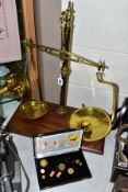 A SET OF BRASS W & T AVERY BALANCE SCALES MOUNTED ON A RECTANGULAR MAHOGANY BASE, together with nine
