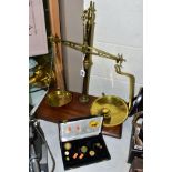 A SET OF BRASS W & T AVERY BALANCE SCALES MOUNTED ON A RECTANGULAR MAHOGANY BASE, together with nine