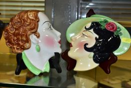 TWO ART DECO POTTERY WALL MASKS OF YOUNG FASHIONABLE LADIES, one with auburn hair, the other wearing