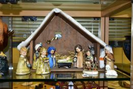 A GOEBEL JANET ROBSON NINE PIECE NATIVITY SET, with a wooden stable/building, comprises baby Jesus