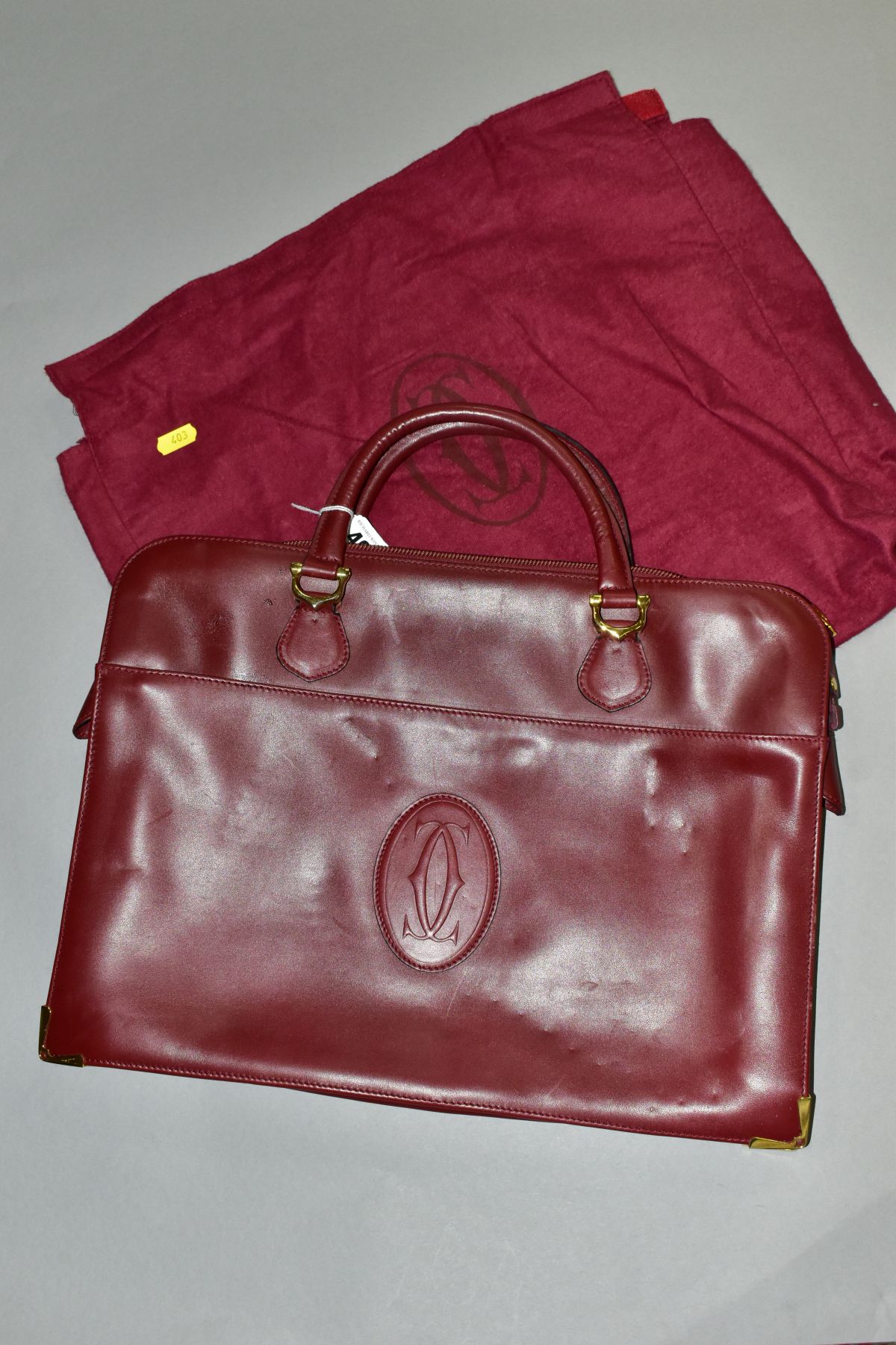 A CARTIER RED LEATHER SOFT BRIEFCASE, case has indentations to the exterior, width 41cm x height