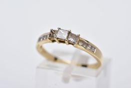 A 14CT GOLD DIAMOND RING, designed as a half eternity ring set with three raised princess cut