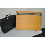 A BLACK AMBASSADOR BRIEFCASE and a British Thornton Drawing board (2)